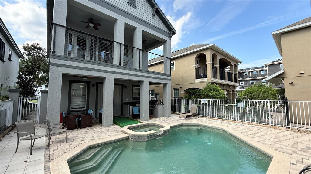 Two multi-story houses stand side-by-side with manicured landscaping and a paved walkway in front — 7810 WHITEMARSH WAY, REUNION, FL