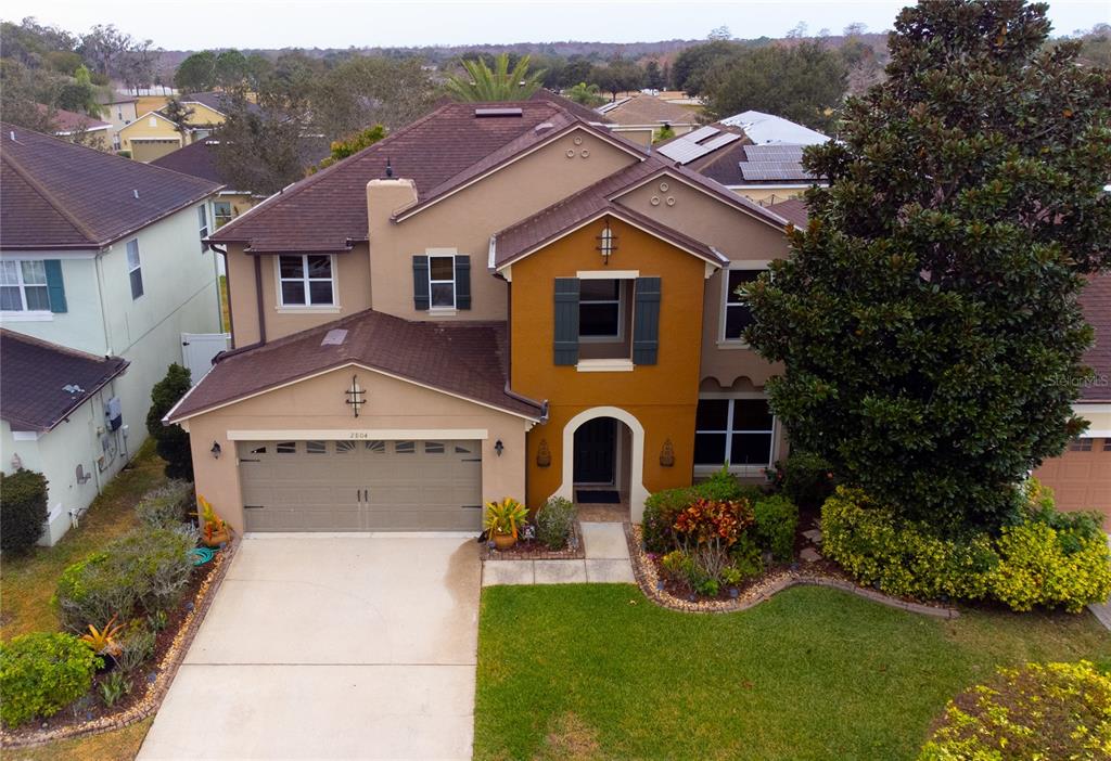An aerial view of a two-story suburban house with a tan and orange exterior — 2804 POLSON DRIVE, KISSIMMEE, FL
