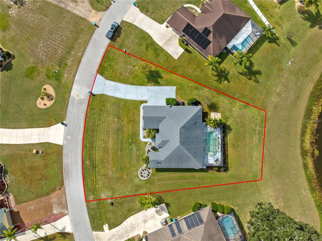 An aerial view shows a house with a pool and driveway on a corner lot — 5430 COUNTY ROAD 125, WILDWOOD, FL