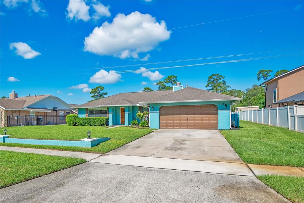 A turquoise single-story house with a brown garage door and a concrete driveway — 4520 BRIDGEWATER DRIVE, ORLANDO, FL