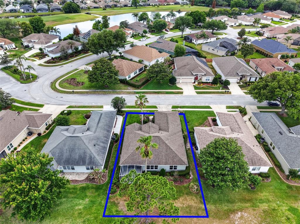 An aerial view shows a single-story house with a screened-in patio and a fenced backyard — 8011 PINE HOLLOW DRIVE, MOUNT DORA, FL