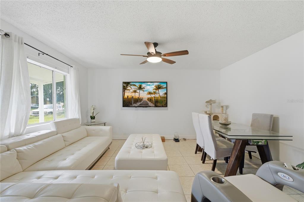 A living room features white leather furniture, a glass dining table, and a wall-mounted television — 524 PIGEON CIR, ORLANDO, FL