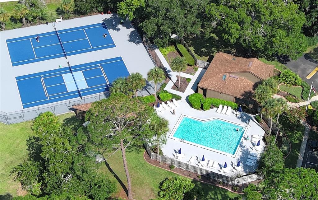 An aerial view shows a swimming pool, a tennis court, and a clubhouse with landscaping — 5 SHERBURY COURT, PALM COAST, FL