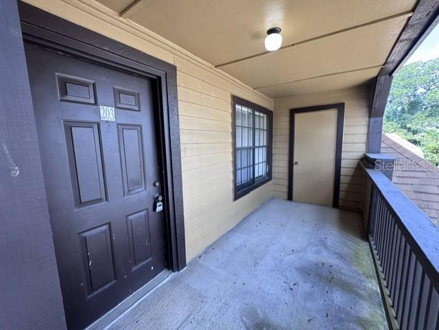 An exterior apartment balcony features a dark brown door, a window, and a utility closet — 320 FORESTWAY CIRCLE UNIT 203, ALTAMONTE SPRINGS, FL
