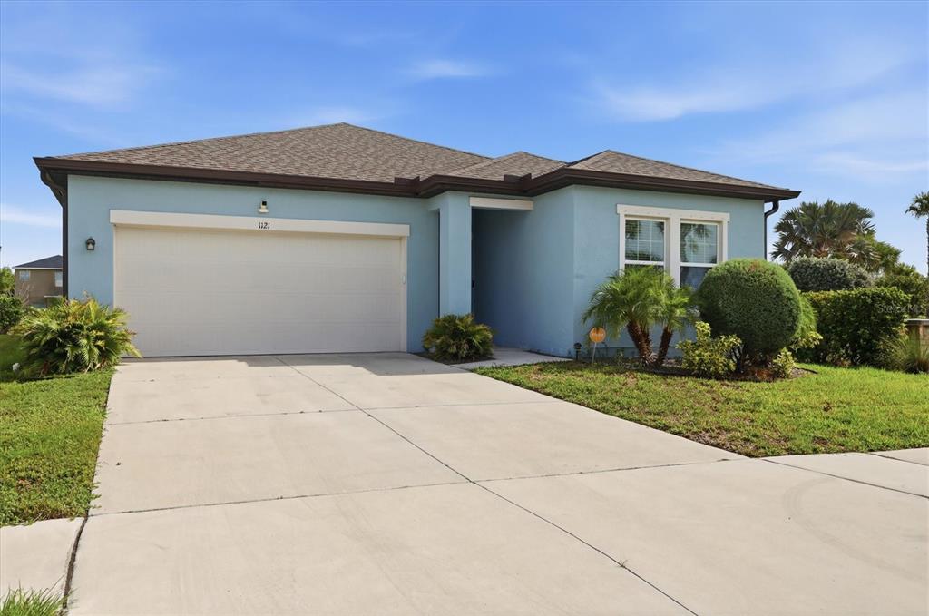A light blue single-story house with a two-car garage and a concrete driveway — 1121 ANCHOR BEND DRIVE, RUSKIN, FL