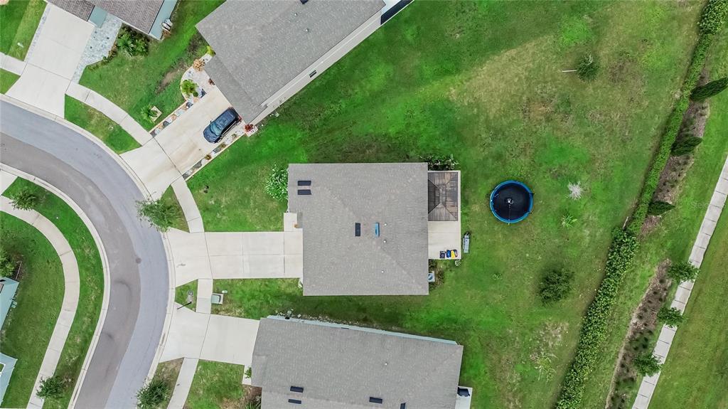 An aerial view shows a suburban house with a driveway, backyard, and a circular pool — 1325 ANCHOR BEND DRIVE, RUSKIN, FL