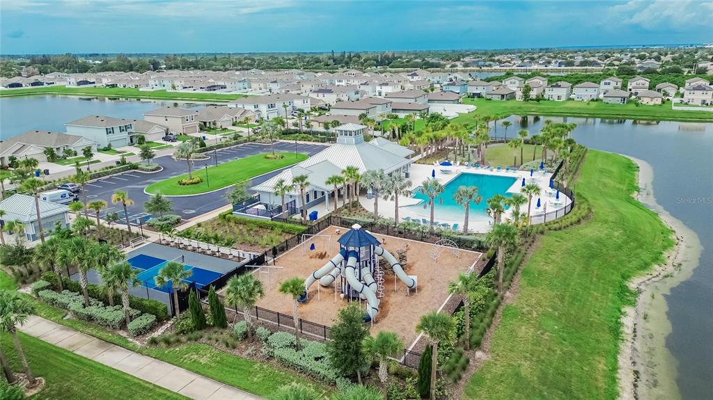 An aerial view of a community clubhouse with a swimming pool, playground, and parking lot — 1325 ANCHOR BEND DRIVE, RUSKIN, FL