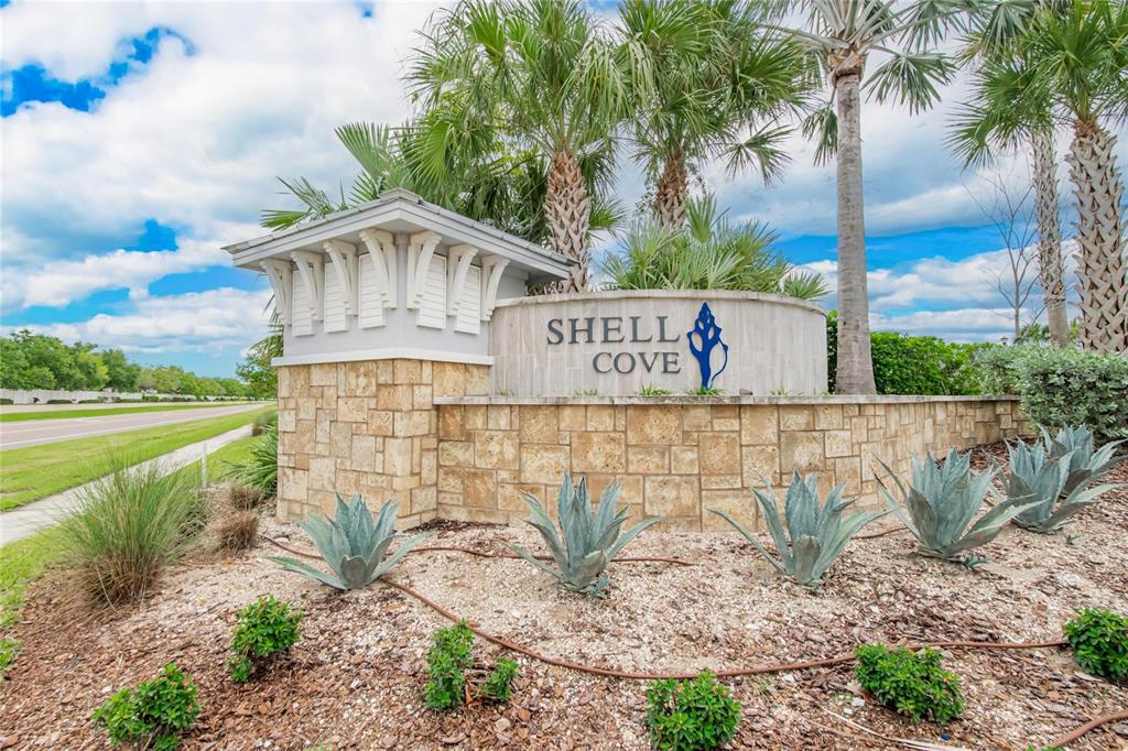 A stone entrance monument for Shell Cove features a blue logo and desert landscaping — 1325 ANCHOR BEND DRIVE, RUSKIN, FL