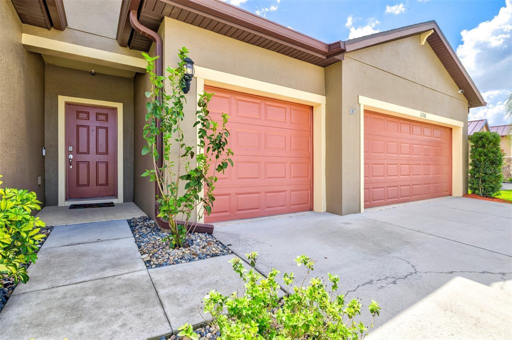 The exterior of a house features a brown front door and two attached garage doors — 11216 58TH STREET CIRCLE E, PARRISH, FL