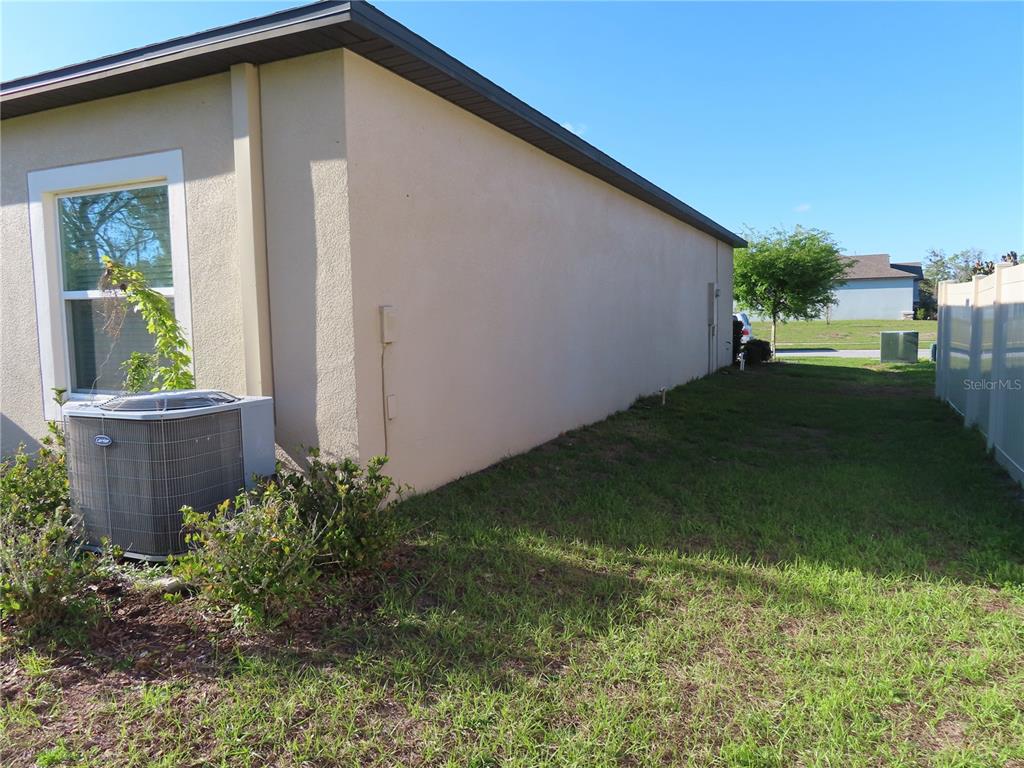 A red front door is centered in a covered entryway with two sun-themed wall decorations — 13149 CONQUISTADOR LOOP, SPRING HILL, FL