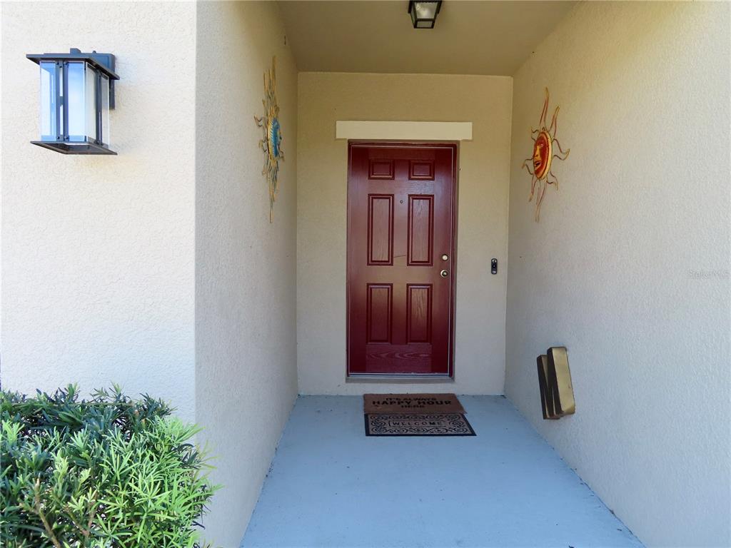 The exterior side of a beige stucco house features an air conditioning unit and lawn — 13149 CONQUISTADOR LOOP, SPRING HILL, FL