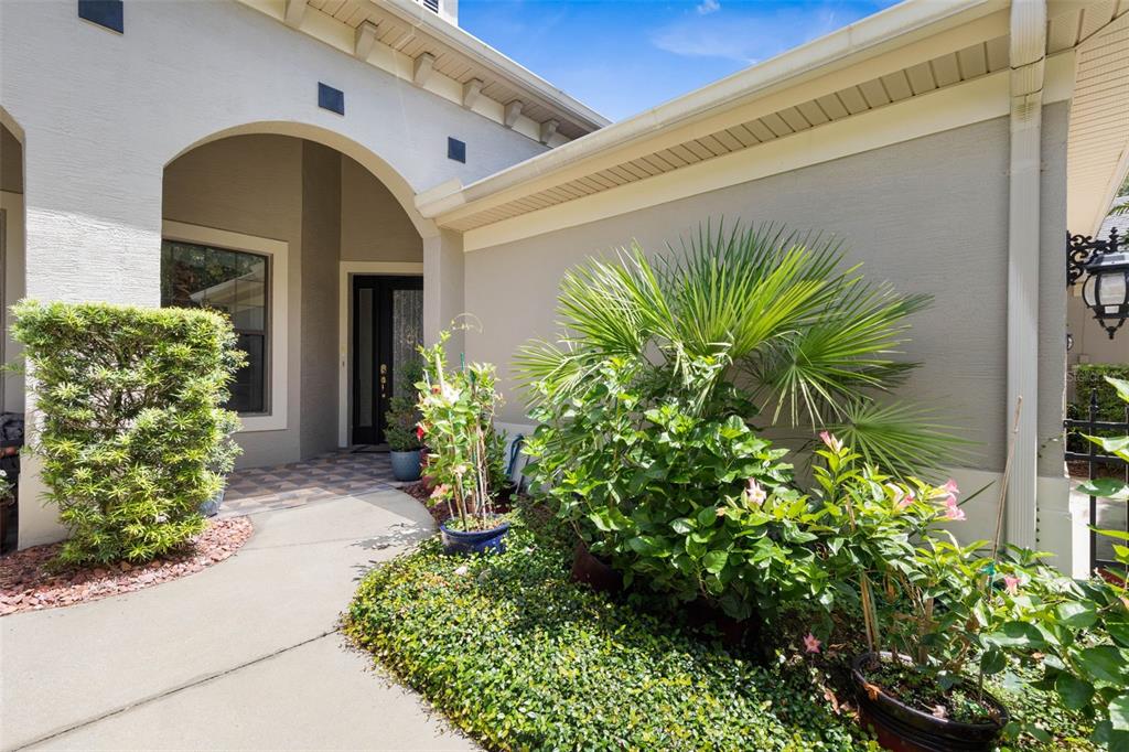 A concrete walkway leads to the front entrance of a house with a covered porch — 7 RIVER LANDING DRIVE, PALM COAST, FL