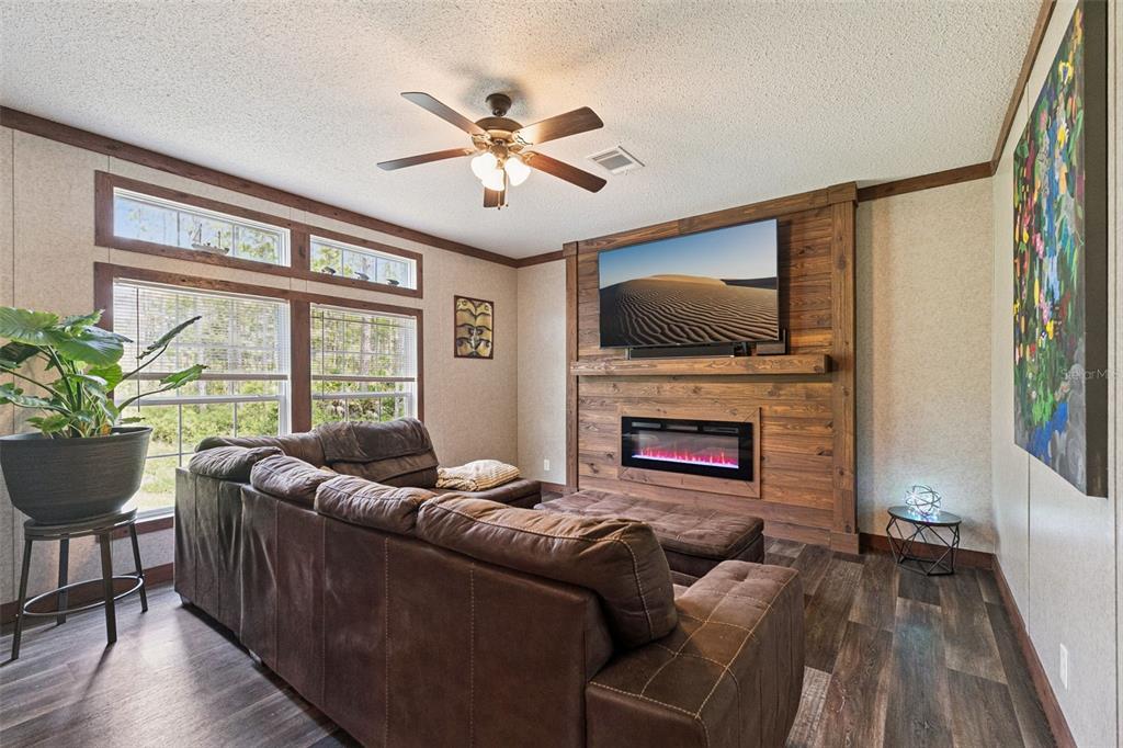 A kitchen with a large wooden island, dark cabinets, and an adjacent living area — 9740 EBERT AVENUE, HASTINGS, FL