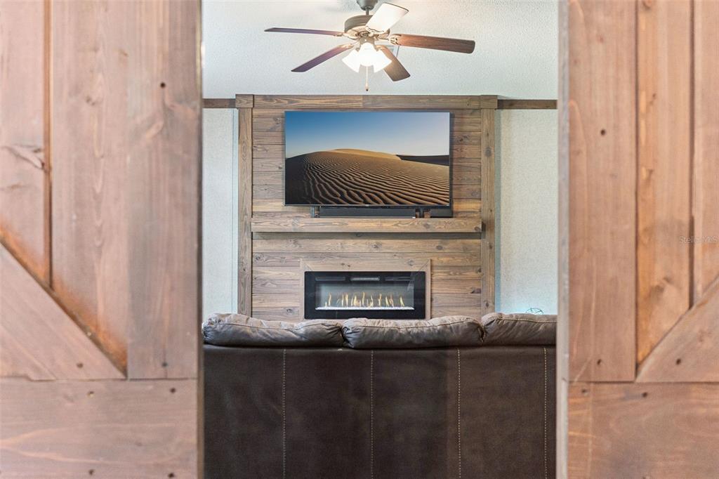 A living room features a large brown sectional sofa, a matching ottoman, and a ceiling fan — 9740 EBERT AVENUE, HASTINGS, FL