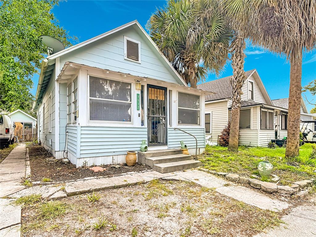 A light blue, single-story house with a front porch, stairs, and a palm tree — 1417 11TH STREET, ST CLOUD, FL