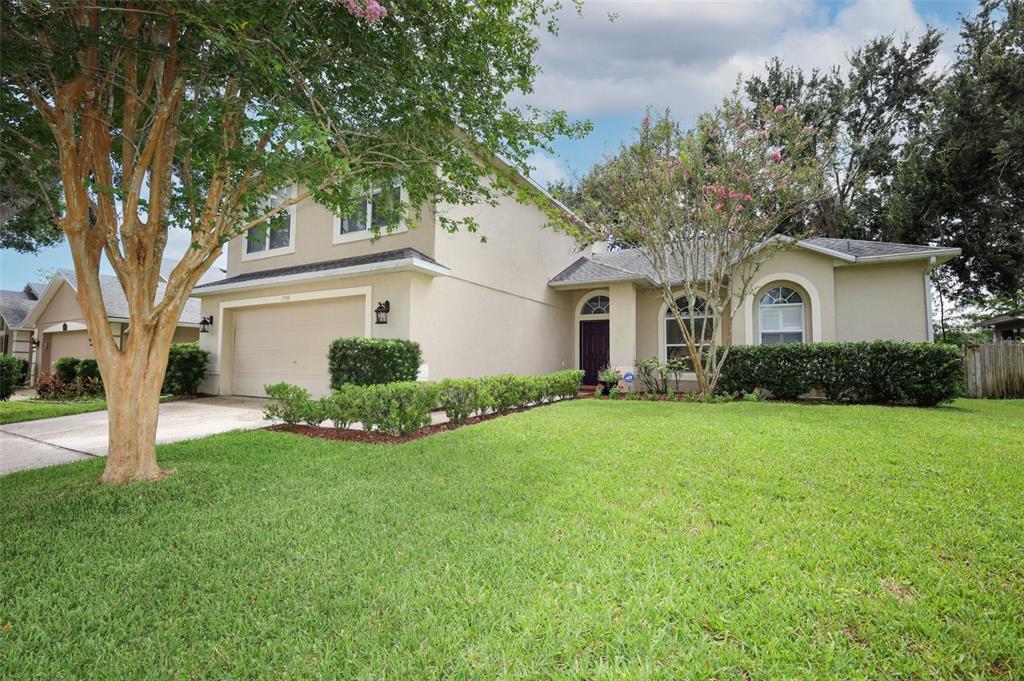 The exterior of a house features a stucco wall, a chimney, and a screened-in porch — 1730 TEALBRIAR AVENUE, OVIEDO, FL