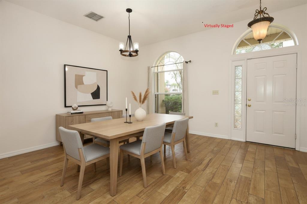 A dining room with wood-look tile floors, an arched doorway, and a large window — 1730 TEALBRIAR AVENUE, OVIEDO, FL