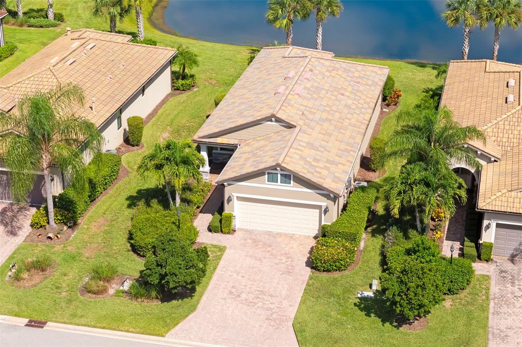 An aerial view shows a tan house with a tiled roof, garage, and landscaped yard — 6726 HAVERHILL COURT, BRADENTON, FL