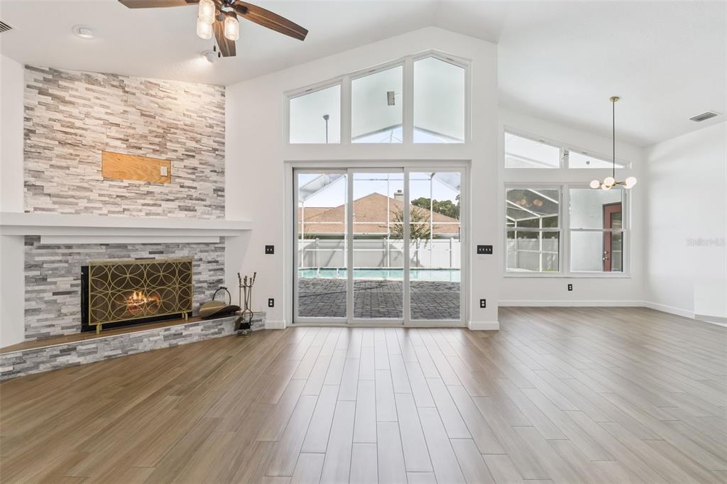 A dining room features a rectangular table, blue chairs, a pendant light, and wood flooring — 2331 RIDGESIDE ROAD, APOPKA, FL