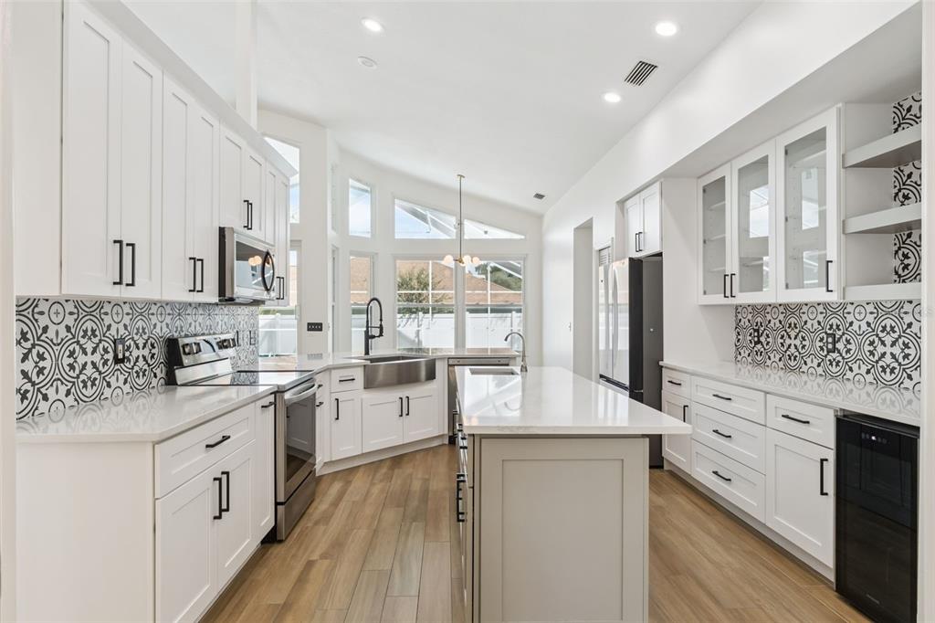 A dining room with a modern light fixture, gray table, and blue and gray chairs — 2331 RIDGESIDE ROAD, APOPKA, FL