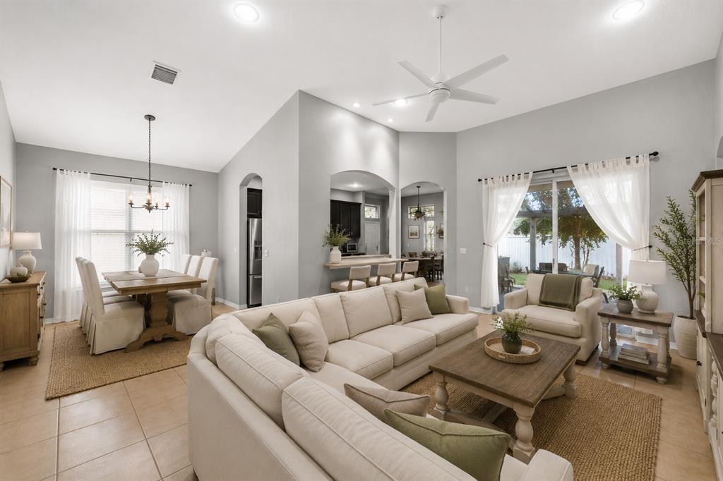 A living room with a white sectional sofa, dining area, and sliding glass doors — 10207 AVELAR RIDGE DRIVE, RIVERVIEW, FL