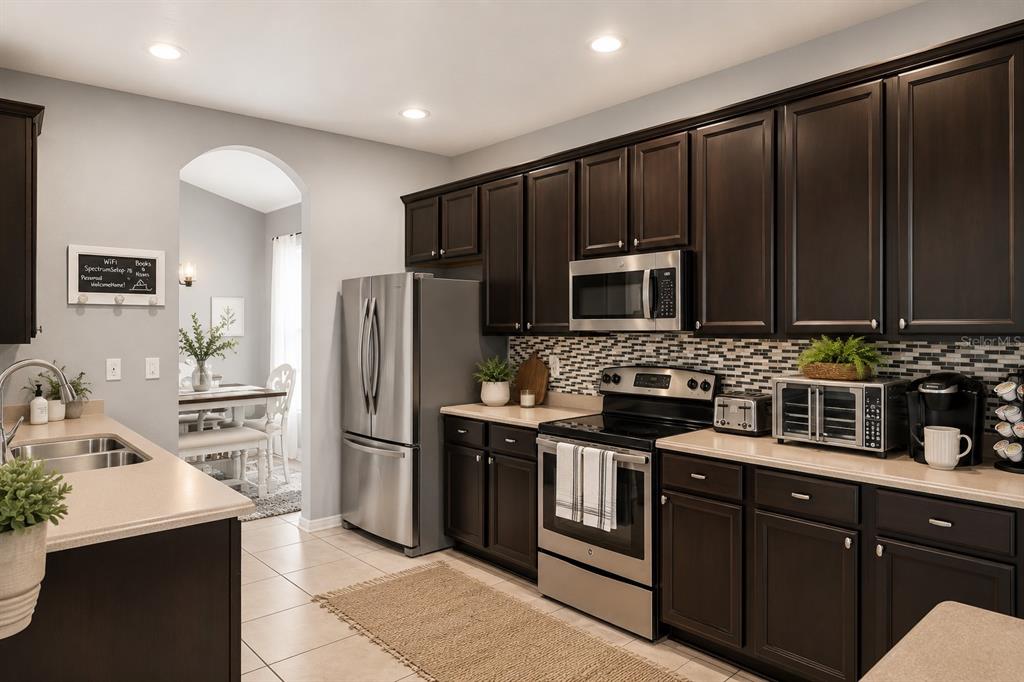 A living room features a white sectional sofa, a wooden coffee table, and built-in wall niches — 10207 AVELAR RIDGE DRIVE, RIVERVIEW, FL