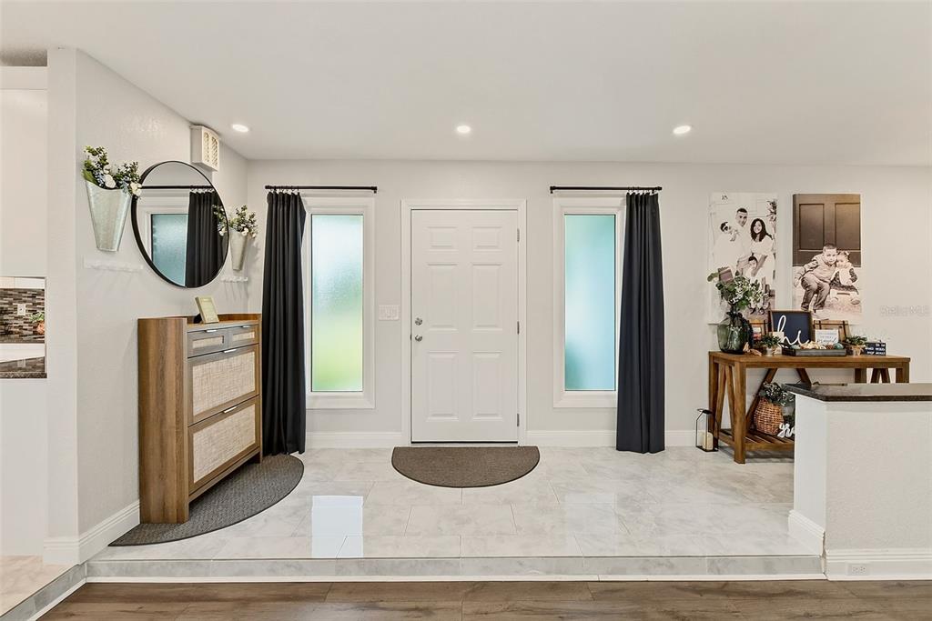 An entryway features a white front door flanked by two windows with dark curtains — 2165 CAMPUS DRIVE, CLEARWATER, FL