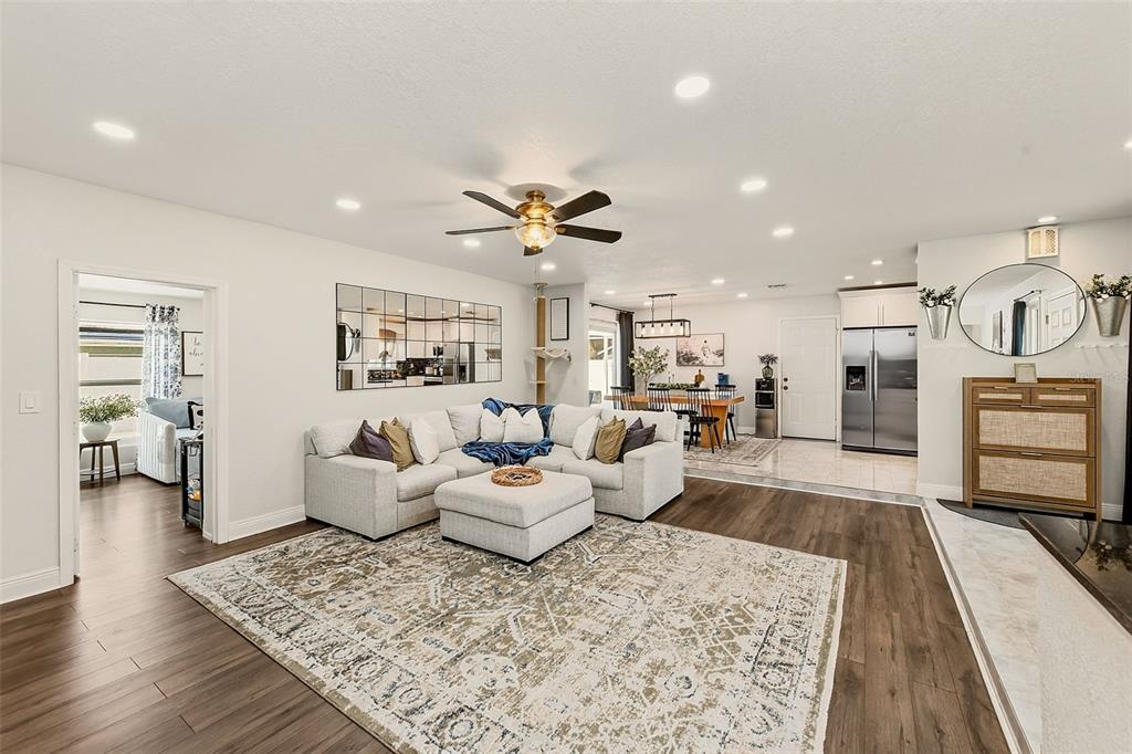 A living room with a sectional sofa, area rug, and an open dining area beyond — 2165 CAMPUS DRIVE, CLEARWATER, FL