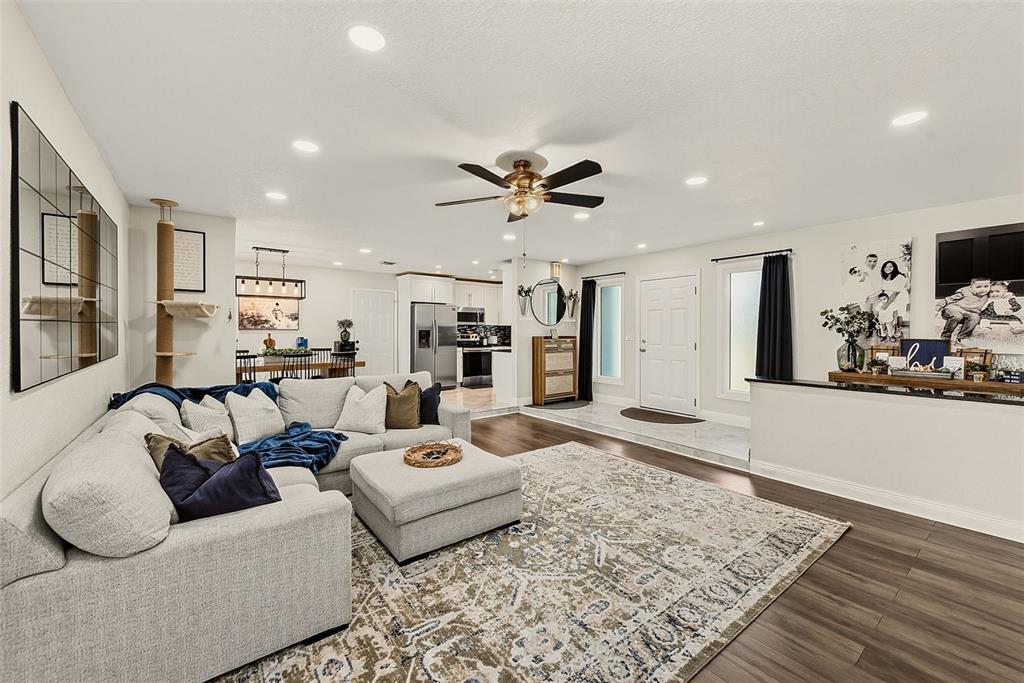 A living room with a sectional sofa, area rug, and an open-concept kitchen in the background — 2165 CAMPUS DRIVE, CLEARWATER, FL