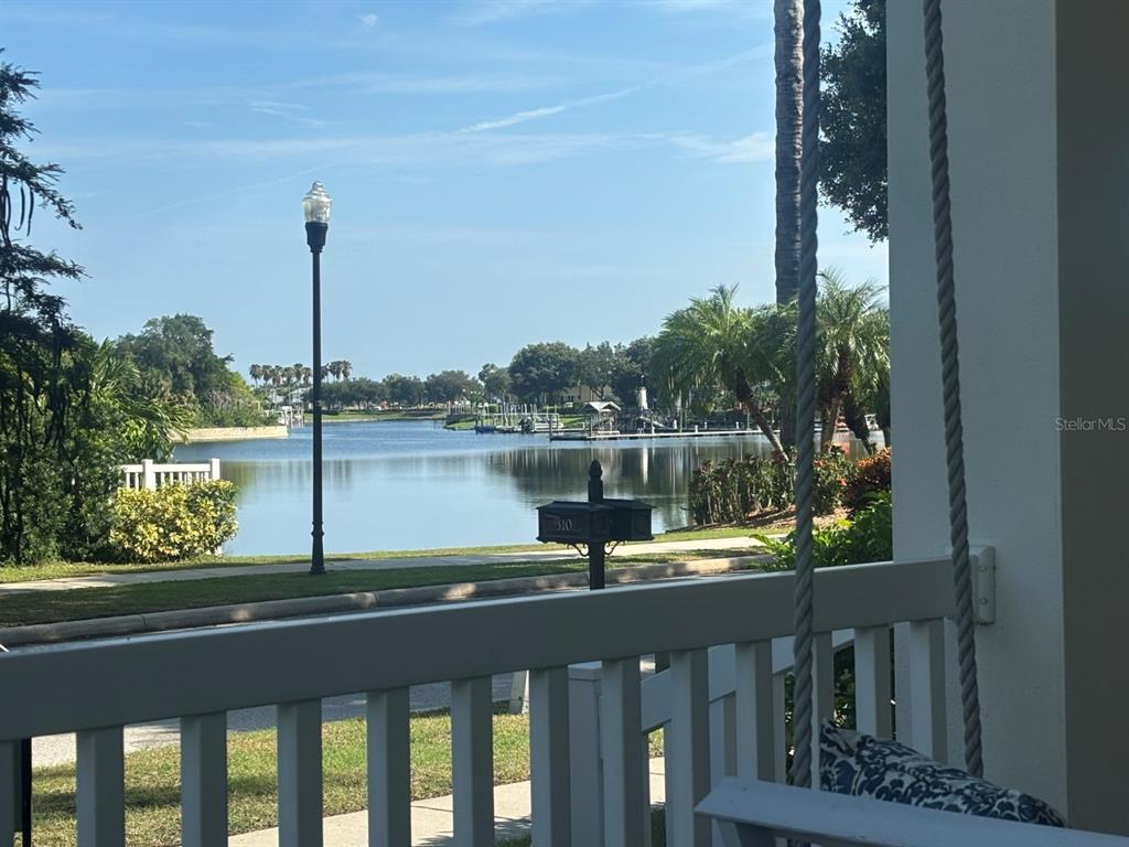 A view of a lake and boat docks from a porch with a hanging swing — 310 MANNS HARBOR DRIVE, APOLLO BEACH, FL