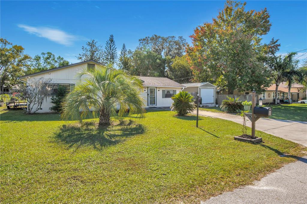 A single-story house with a palm tree in the front yard and a detached garage — 11 ASTER DRIVE, DEBARY, FL