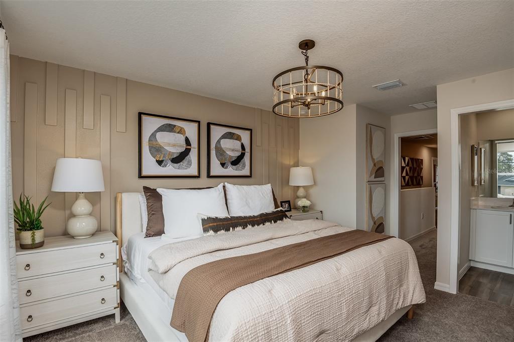 A bedroom features a bed with a brown runner, wall paneling, and a drum chandelier — 4247 HILLOCK BOULEVARD, HAINES CITY, FL