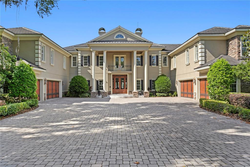 A large two-story estate with a paved circular driveway and a symmetrical columned entrance — 9205 POST ROAD, ODESSA, FL