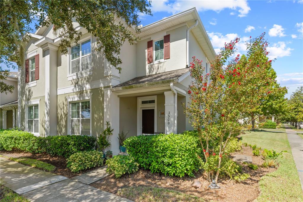 A two-story house with beige stucco siding, red shutters, and a covered front entryway — 3500 SEBASTIAN BRIDGE LANE, ST CLOUD, FL