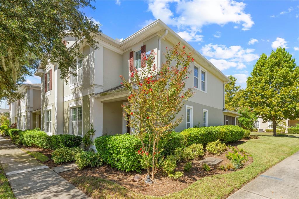 A two-story house exterior with light-colored stucco, red shutters, and a landscaped front yard — 3500 SEBASTIAN BRIDGE LANE, ST CLOUD, FL