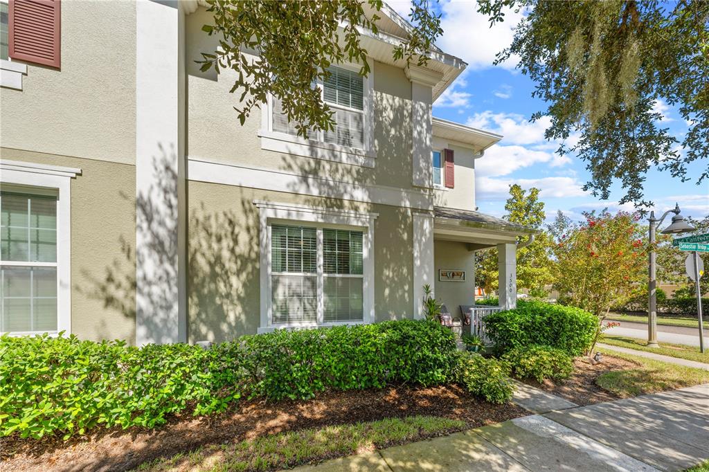 A two-story house exterior with beige stucco walls, white trim, and a covered front porch — 3500 SEBASTIAN BRIDGE LANE, ST CLOUD, FL