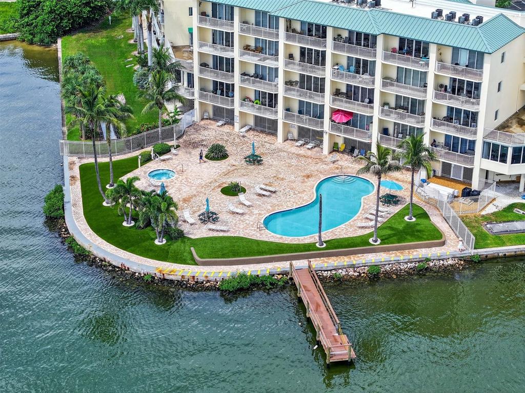 An aerial view of a waterfront condominium complex with a pool and a parking lot — 8800 BAY PINES BOULEVARD UNIT 216, ST PETERSBURG, FL