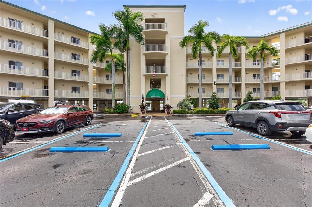 A balcony with blue cushioned chairs overlooks a marina and a wide body of water — 8800 BAY PINES BOULEVARD UNIT 216, ST PETERSBURG, FL