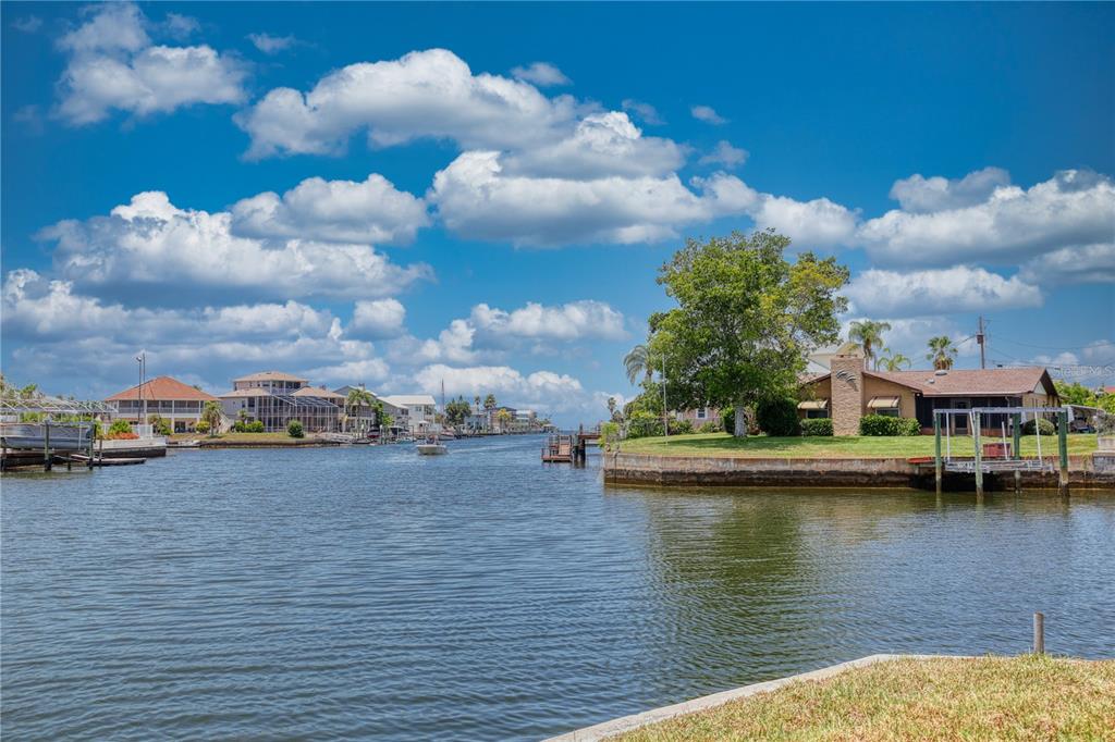 An aerial view shows a waterfront house on a corner lot with a private dock — 4365 4TH ISLE DRIVE, HERNANDO BEACH, FL