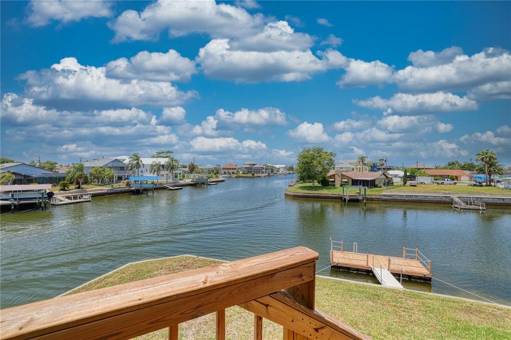A kitchen features white cabinets, granite countertops, a stainless steel refrigerator, and a breakfast bar — 4365 4TH ISLE DRIVE, HERNANDO BEACH, FL