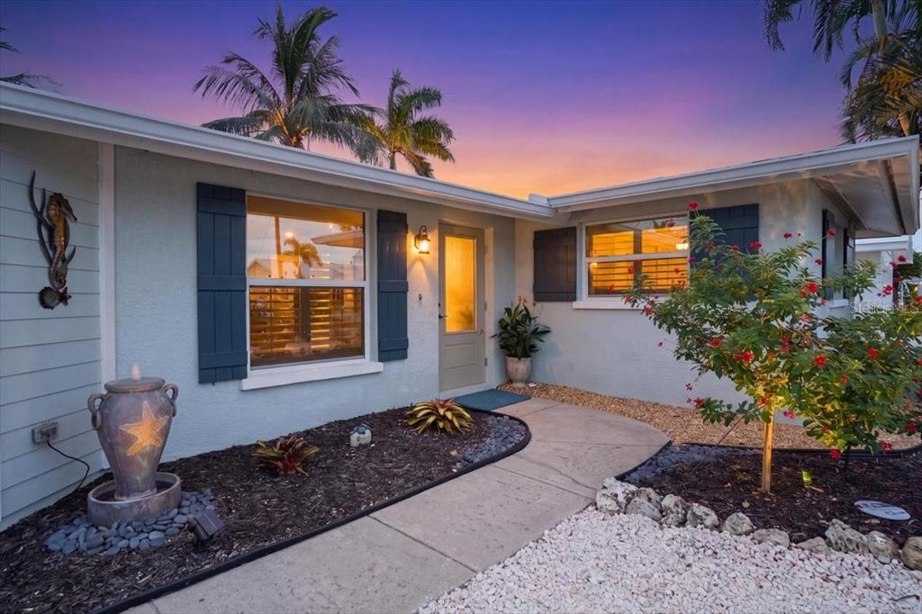 The exterior of a light blue house features a front door, shutters, and landscaping — 520 69TH STREET, HOLMES BEACH, FL