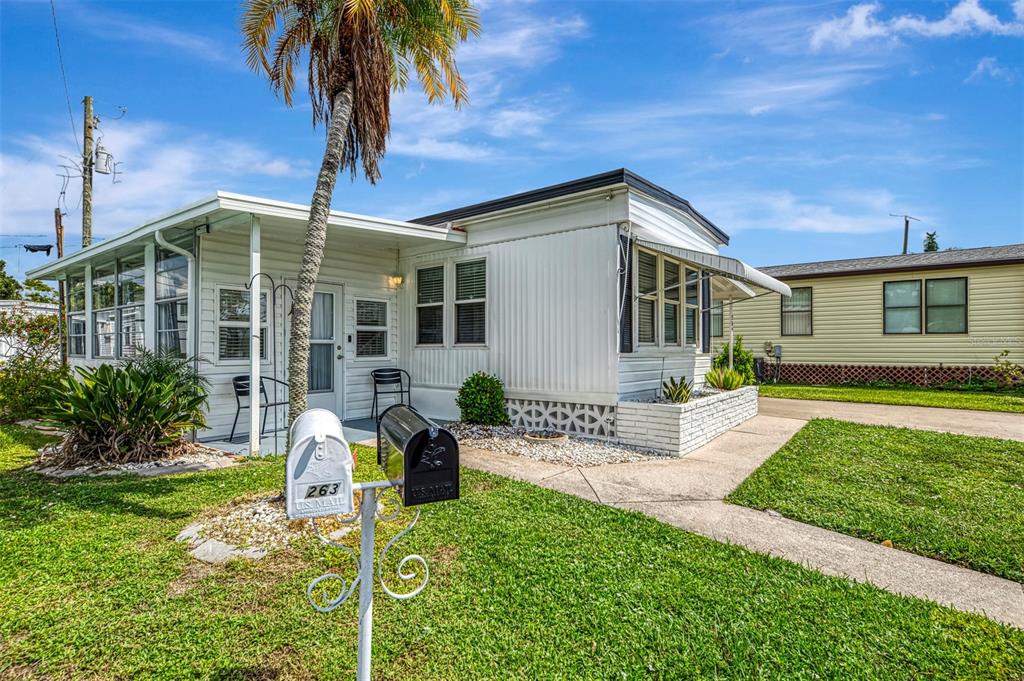 A white mobile home with a palm tree, a front porch, and two mailboxes — 259 INNER DRIVE E, VENICE, FL