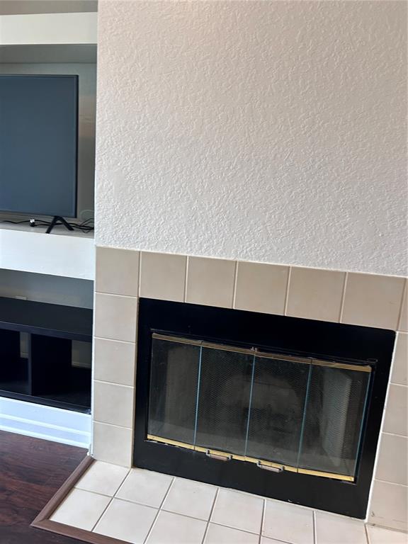 A living room features a fireplace with beige tile surround and an adjacent built-in shelf — 13015 PLANTATION PARK CIRCLE UNIT 1031, ORLANDO, FL