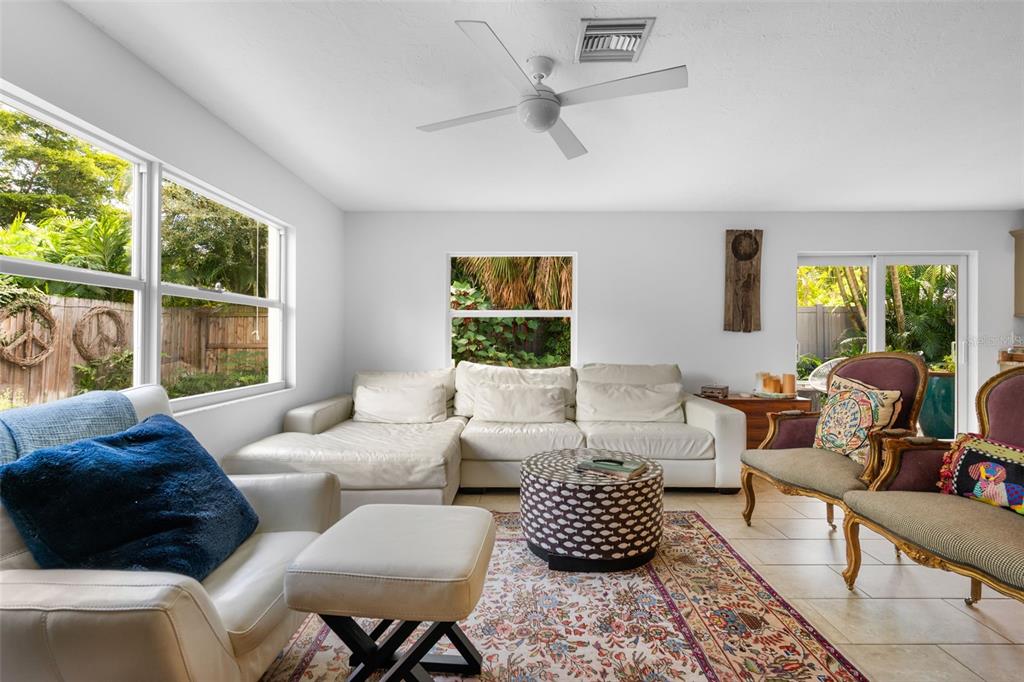 A living room features a white sectional sofa, patterned ottoman, and two vintage-style armchairs — 1750 ALTA VISTA STREET, SARASOTA, FL