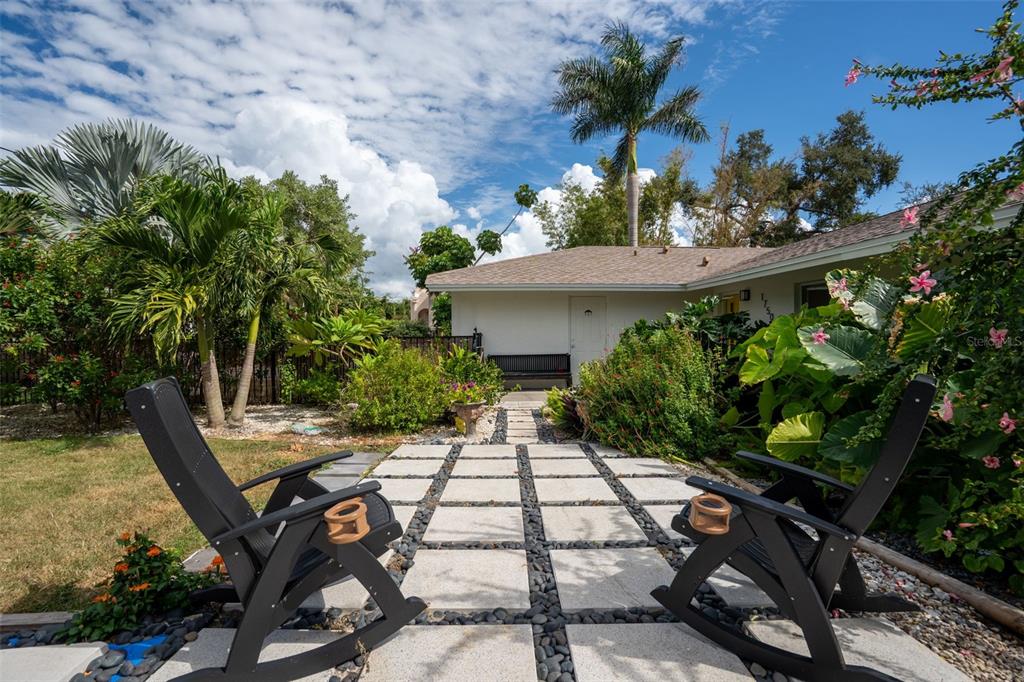 Two black rocking chairs sit on a stone paver patio in front of a house — 1750 ALTA VISTA STREET, SARASOTA, FL