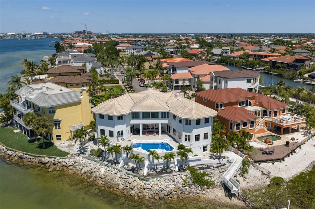 An aerial view of a waterfront house with a swimming pool and rocky shoreline — 1021 SYMPHONY ISLES BOULEVARD, APOLLO BEACH, FL