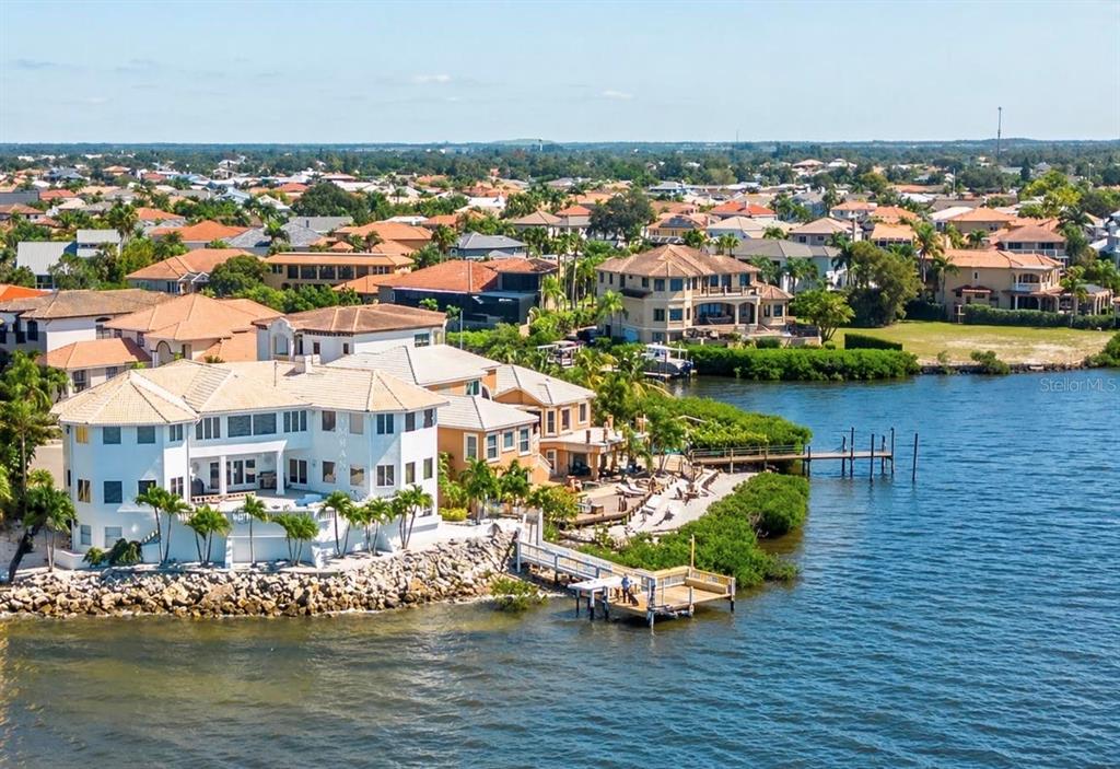 An aerial view of waterfront houses with docks along a canal in a residential neighborhood — 1021 SYMPHONY ISLES BOULEVARD, APOLLO BEACH, FL