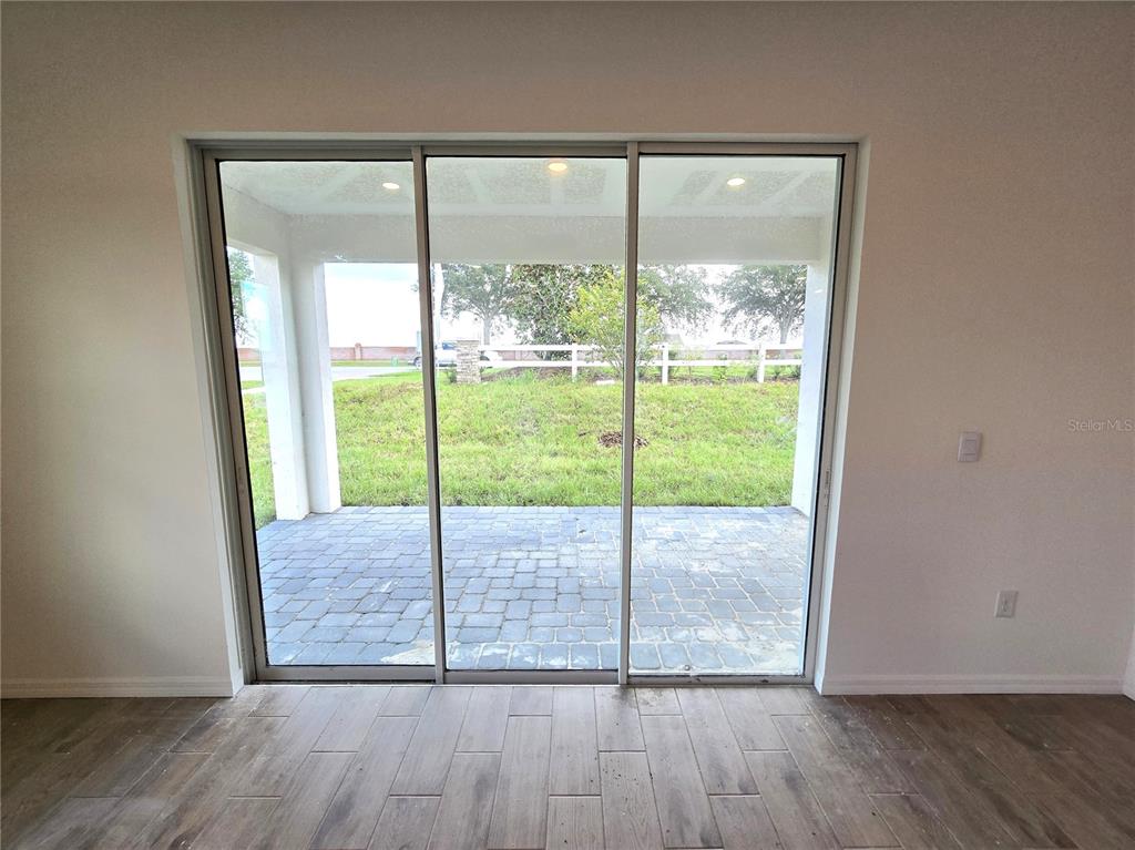 A modern kitchen features white cabinets, stainless steel appliances, a tiled backsplash, and a sink island — 6470 CHORUS DRIVE, MASCOTTE, FL
