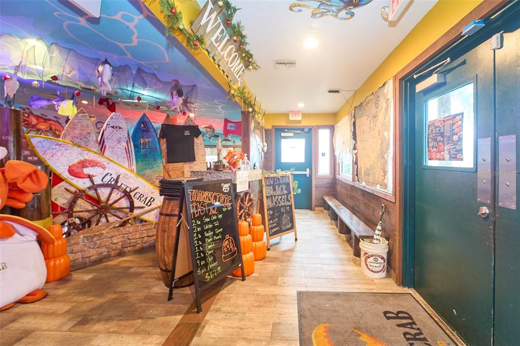 The entrance area of a restaurant features surfboards, chalkboard menus, and wooden flooring — 704 E BRANDON BOULEVARD, BRANDON, FL