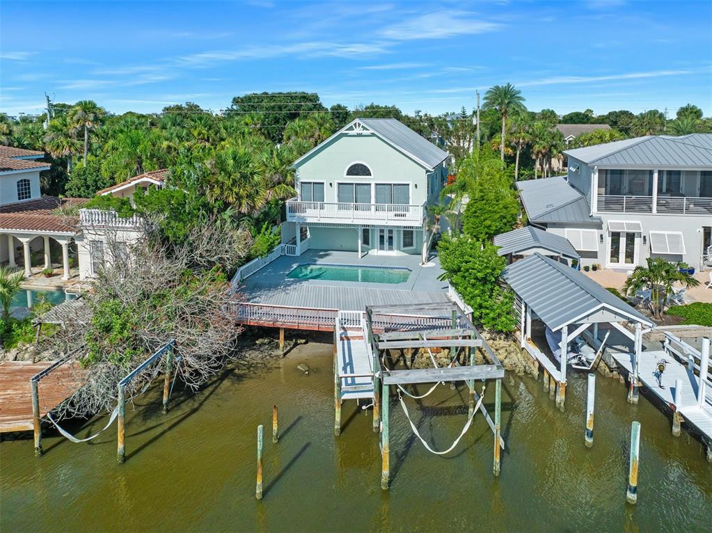 A waterfront house features a swimming pool, a wooden deck, and a private boat dock — 3110 JOHN ANDERSON DRIVE, ORMOND BEACH, FL
